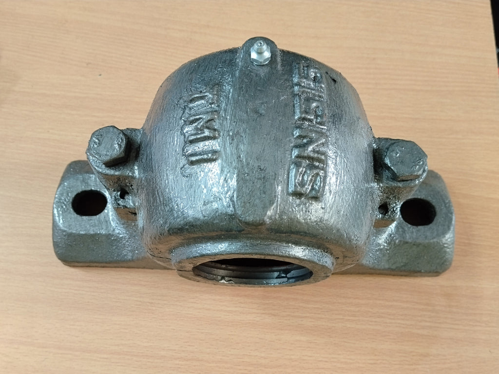 A cast iron SN 515 PLUMMER BLOCK resting on a light wood surface.