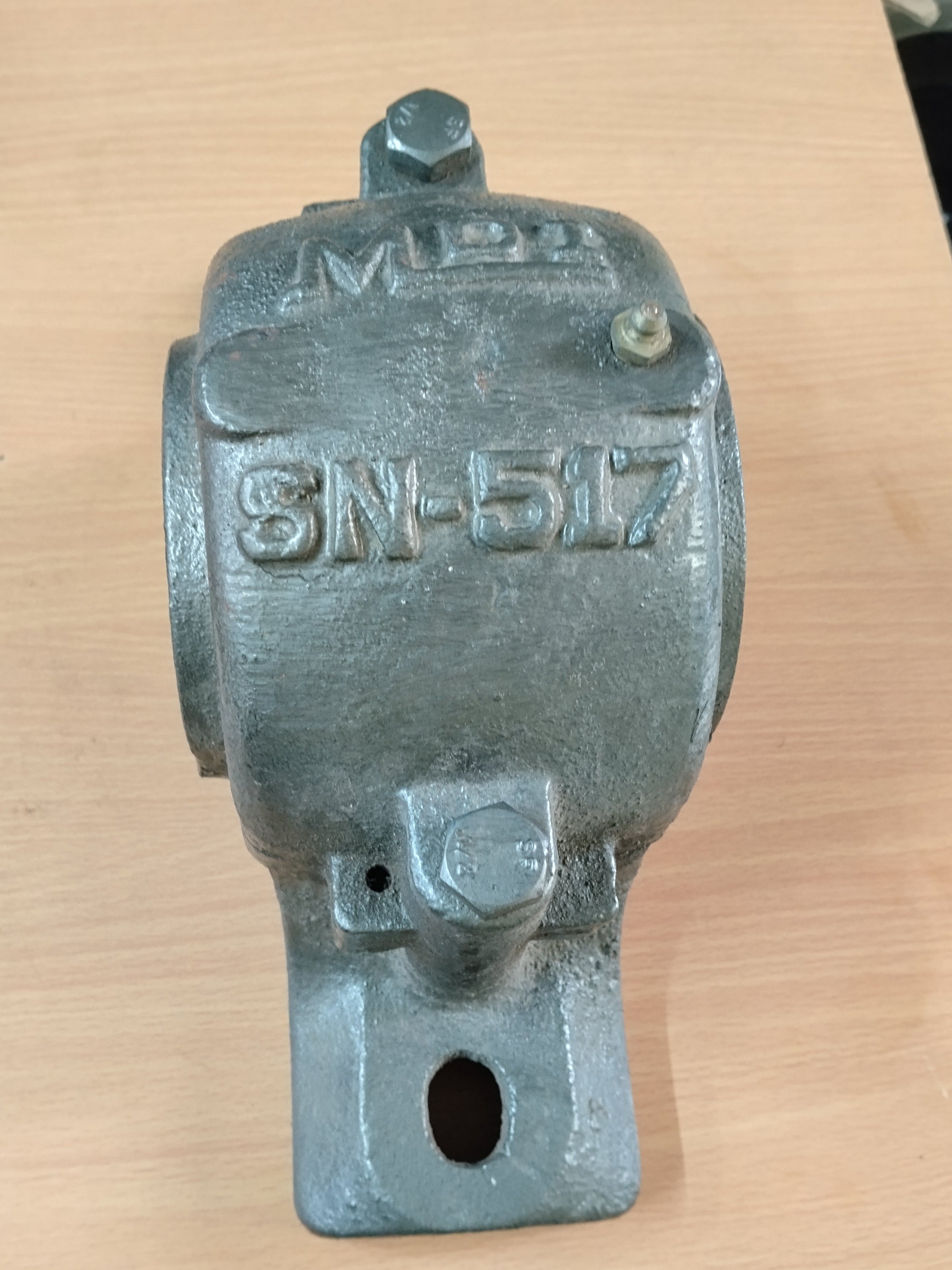 A cast iron SN 517 PLUMMER BLOCK resting on a light wood tabletop.